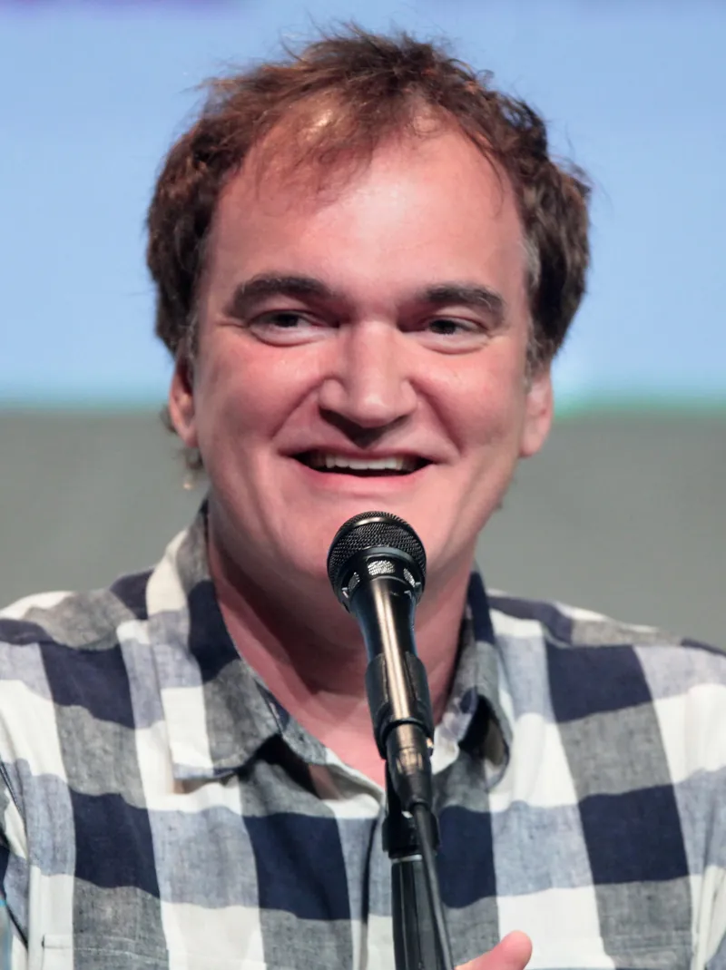Director Quentin Tarantino smiling while speaking into a microphone